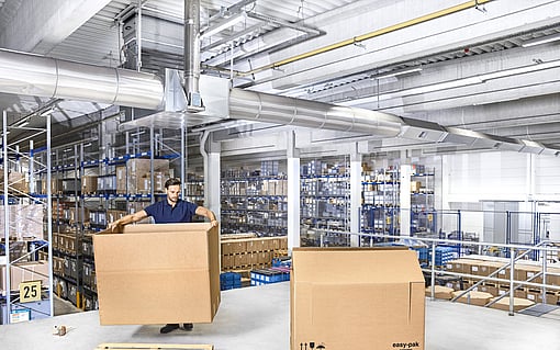 A man is setting up a Mondi Easy-Pak corrugated solution designed for large and heavy-duty items.
