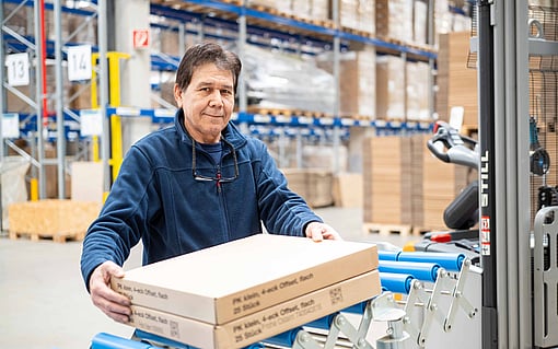 A conveyor belt transporting a corrugated box with a barcode printed on.
