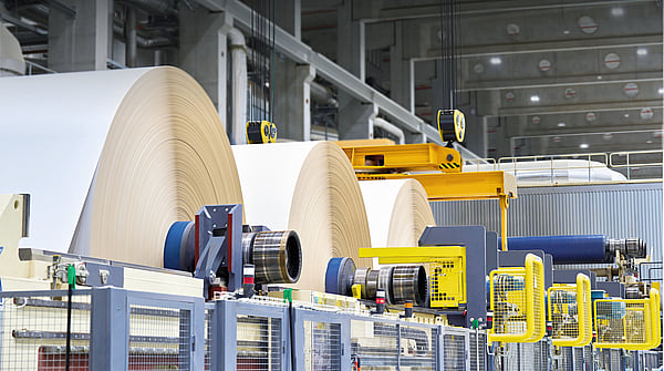 Interior of a Mondi warehouse showing multiple jumbo paper reels stored side by side.