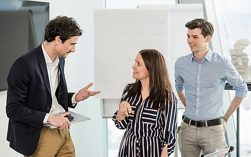 Three people having a professional conversation.