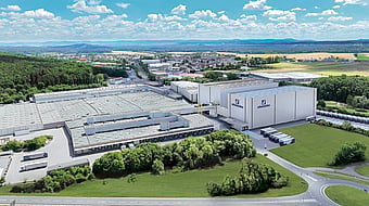 Aerial shot of Schumacher packaging western Europe operations building surrounded by trees and roads.