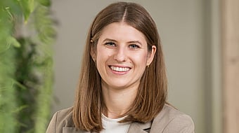 Profile picture of Vera, a young woman with light brown long hair and blue eyes, smiling friendly into the camera