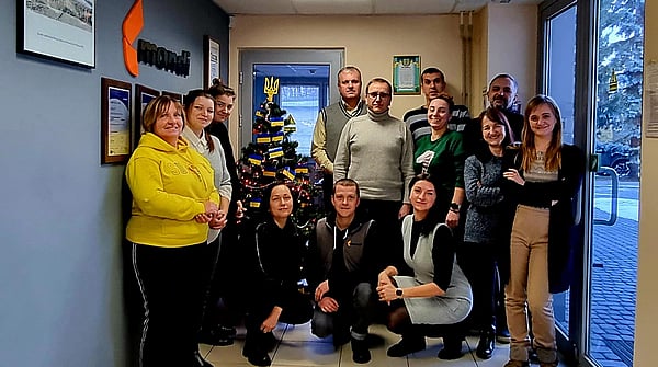 Mondi colleagues gathered together next to a Christmas tree to take a photograph.