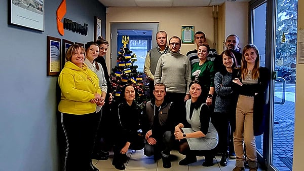 Mondi colleagues gathered together next to a Christmas tree to take a photograph.