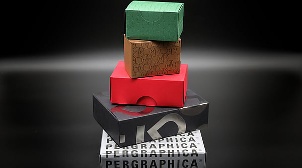 five Pergraphica boxes stacked on top of each other getting smaller as the tower gets larger. Box colours are green, red gold, black and white.